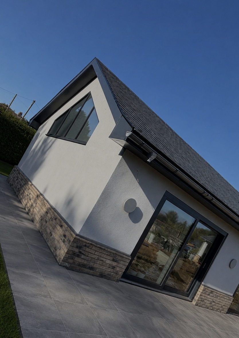 A recently completed Henry Daniel new build, rendered walls with a stone plinth and full-height glazing