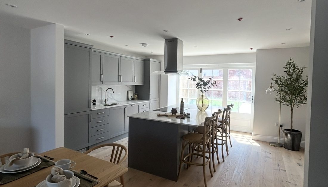 An open-plan kitchen and dining space finished in soft grey